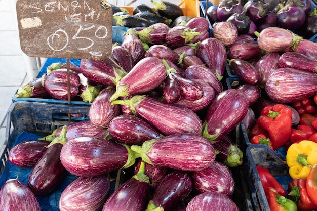 Fresh vegetables on farmers market stall aubergines and peppers