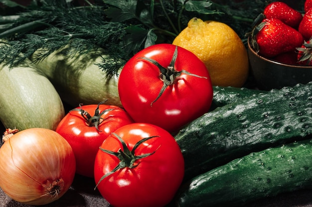 Fresh vegetables fruits berries and greens on a brown background still life