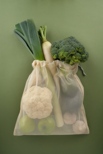 Fresh vegetables and fruits in a reusable fabric eco bag broccoli leeks cauliflower garlic avocado