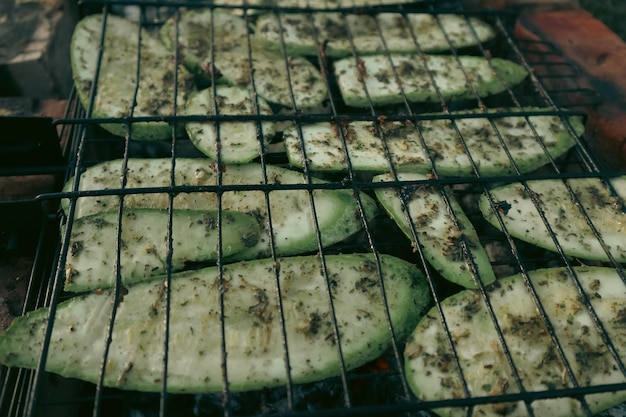 Fresh vegetables on grill for outdoor barbecue Chopped zucchini and carrots roasting on fire