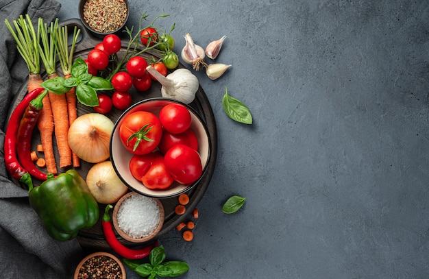 Fresh vegetables herbs and spices on a cutting board on a dark background