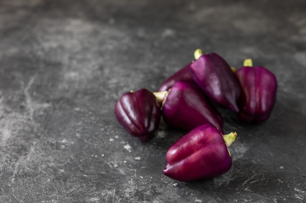 Fresh vegetables. Purple pepper on a dark background