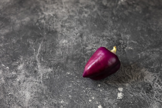 Fresh vegetables. Purple pepper on a dark table