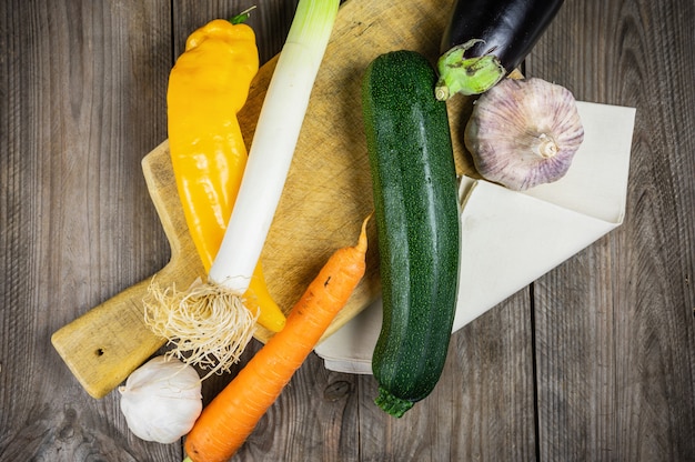 Fresh vegetables ready for cooking shot on rustic wooden table.