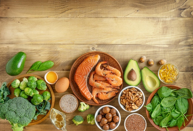 Fresh vegetables seafood and nuts on wooden background Copy space