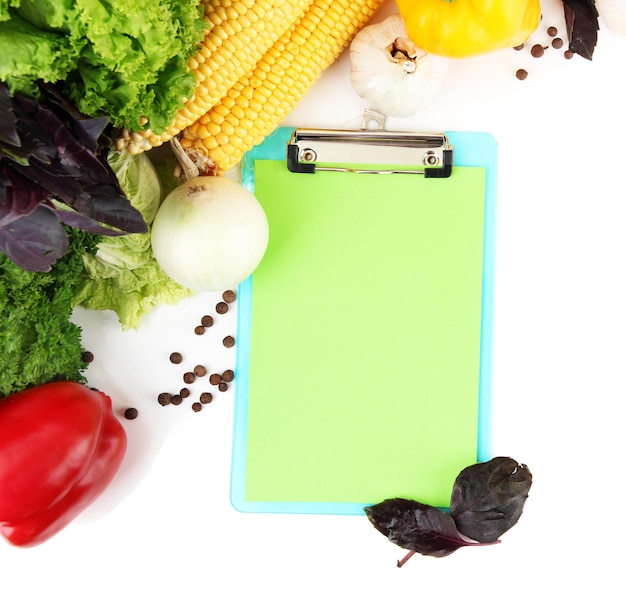 Fresh vegetables and spices and paper for notes isolated on white