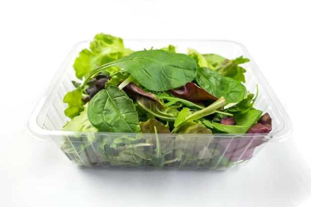 Fresh vegetarian salad arugula spinach red spinach lettuce isolated on white background Image of different useful leaves in a plastic tray on white