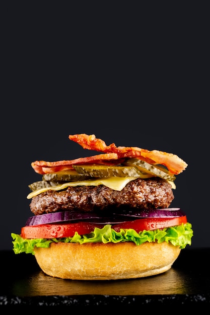 Fresh vegetarian tasty burger on a black background. Making a burguer in stages