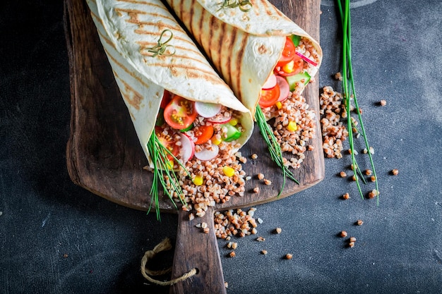 Fresh vegetarian tortilla with groats cherry tomatoes and chive