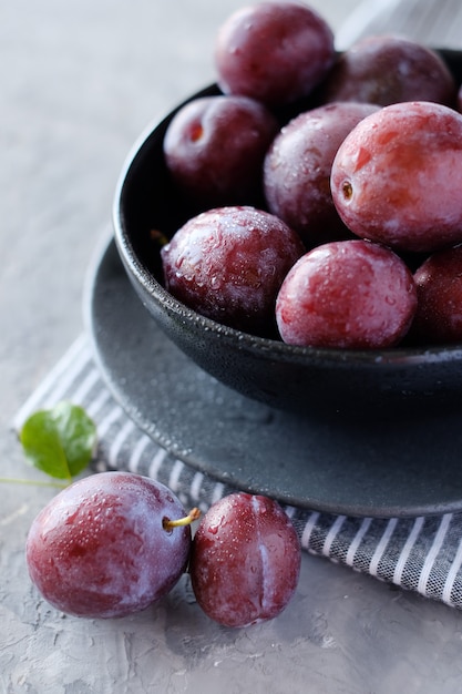 Fresh violet plums at dark gray table background