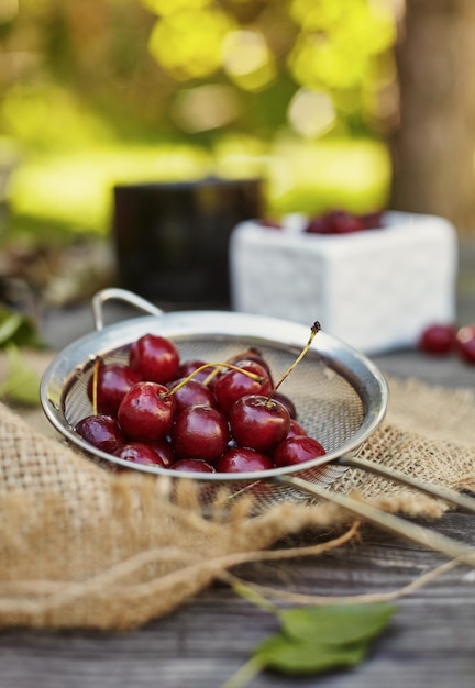 Fresh washed cherries on a sieve. Composition on the table