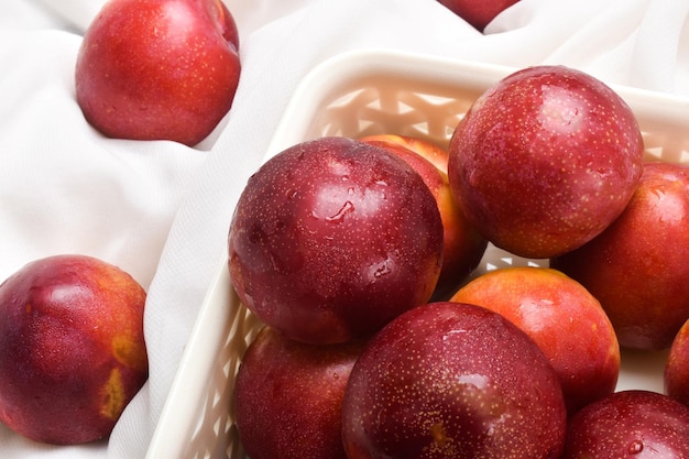 Fresh and Watery Red Plums In A Basket