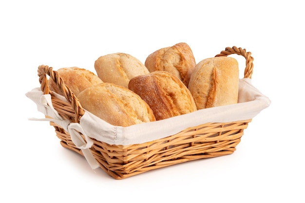 Fresh wheat buns in a wicker basket isolated on white