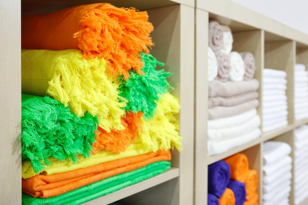 Fresh White and colorful Hotel Towels Folded and Stacked on a Shelf