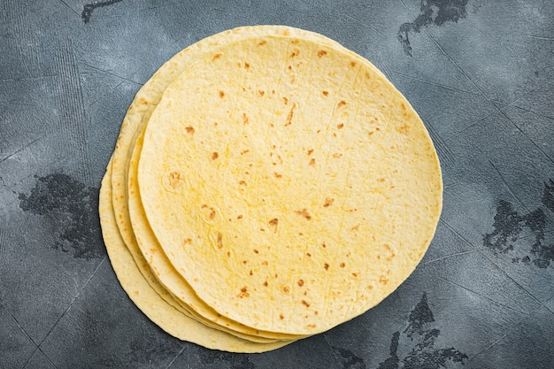 Fresh yellow corn tortillas, on gray background, top view flat lay  with copy space