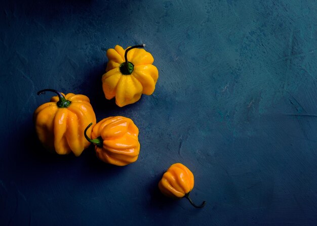 Fresh yellow peppers on blue background