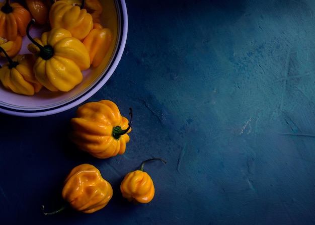 Fresh yellow peppers on blue background