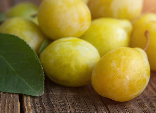 Fresh yellow plum closeup yellow plum in on a wooden table rustic background