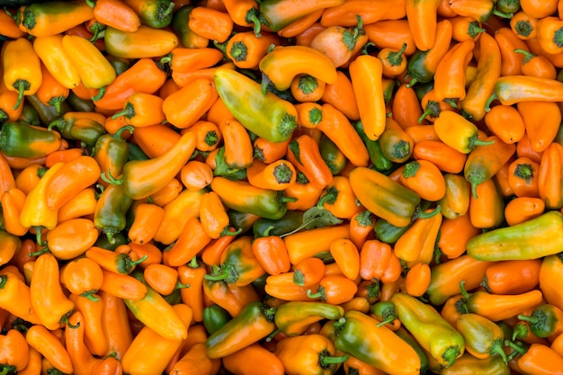 Fresh yellow pointed peppers texture background Close up Street vegetable market