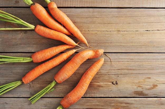 Fresh young whole carrots on wooden rustic surface