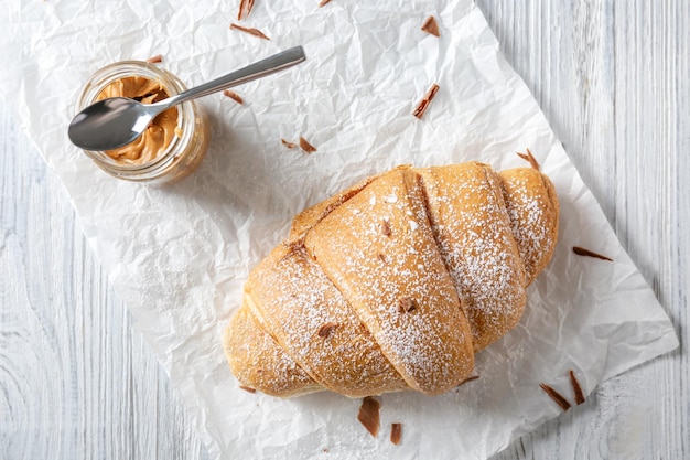 Fresh yummy croissant on parchment paper