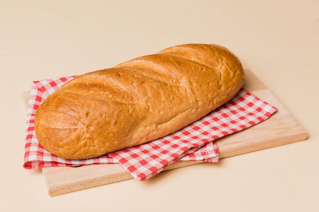 Freshly baked bread on cutting board against white wooden background perspective view bread with copy space