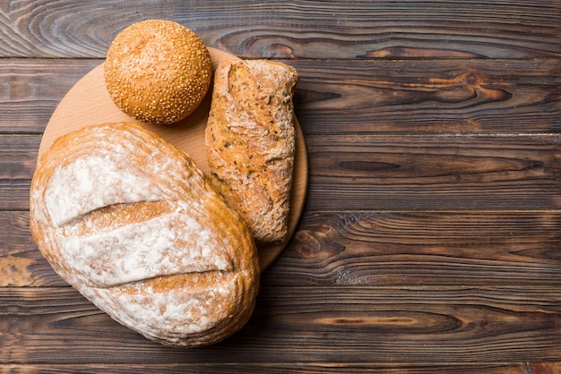 Freshly baked bread on cutting board against white wooden background top view bread with copy space