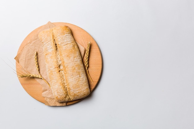 Freshly baked bread on cutting board against white wooden background top view bread with copy space