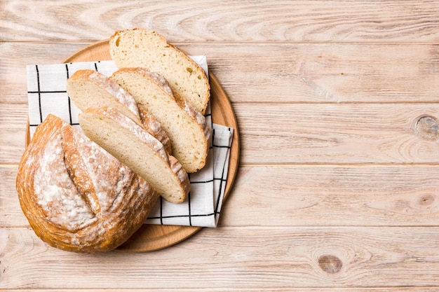 Freshly baked bread slices on cutting board against white wooden background top view Sliced bread