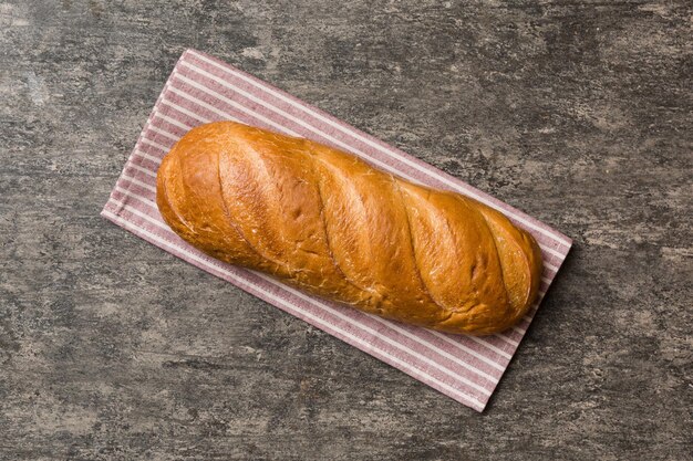 Freshly baked bread with napkin on rustic table top view Healthy white bread loaf isolated