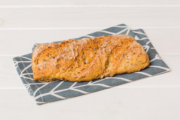 Freshly baked bread with napkin on rustic table top view Healthy white bread loaf isolated