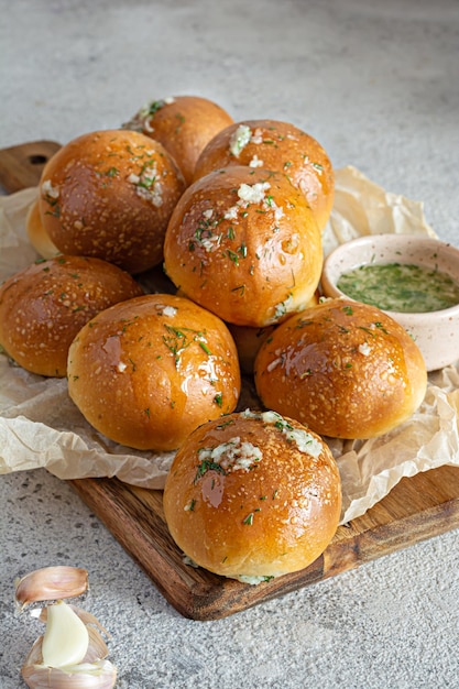 Freshly baked buns (pampushki) with garlic and dill for the first course (soup)on a wooden board.