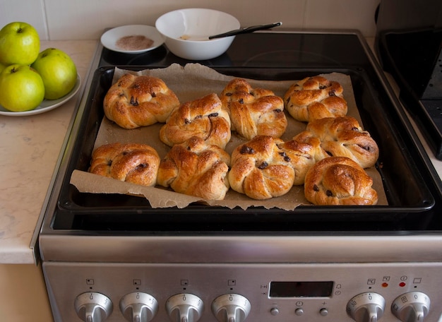 Freshly baked buns in a pan stand on an electric stove in the kitchen