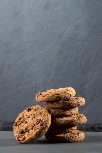 Freshly baked Chocolate chip cookies on a dark stone with place for text.