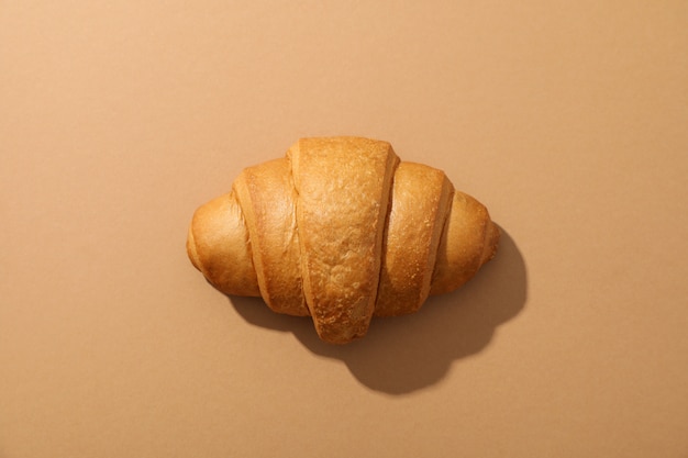 Freshly baked croissant on craft background, top view