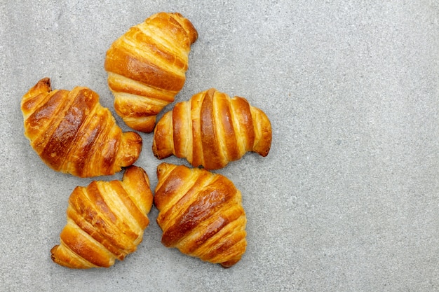 Freshly baked croissants on a gray background