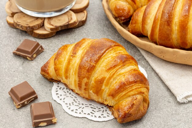 Freshly baked croissants with coffee on a gray background