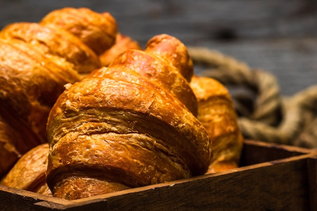 Freshly baked croissants on a wooden box