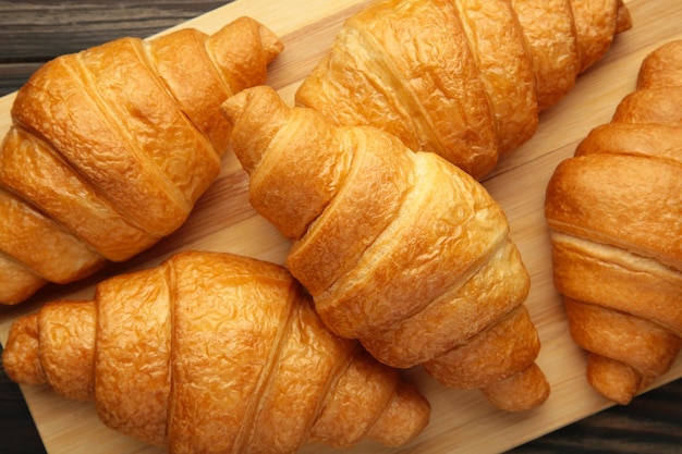 Freshly baked croissants on wooden cutting board