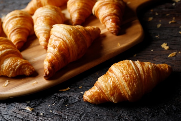 Freshly baked croissants on wooden cutting board