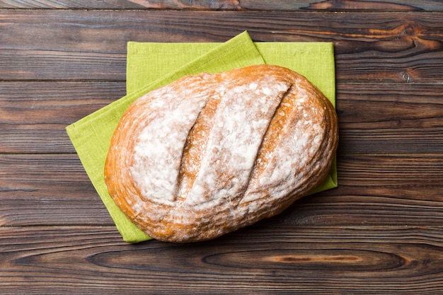 Freshly baked delicious french bread with napkin on rustic table top view Healthy white bread loaf