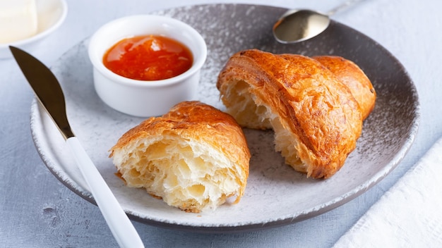 A freshly baked French Croissant butter and jam