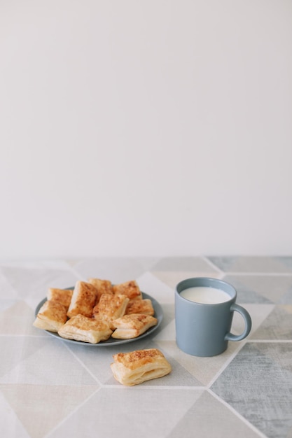 Freshly baked homemade pastry on kitchen table breakfast with puff buns and a glass of milk