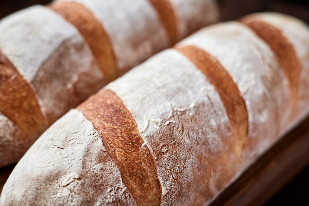 Freshly baked homemade wheat loaves on wooden background