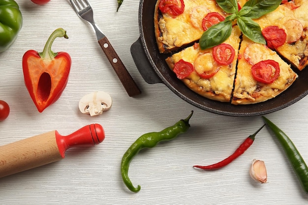 Photo freshly baked pizza in a pan on wooden background