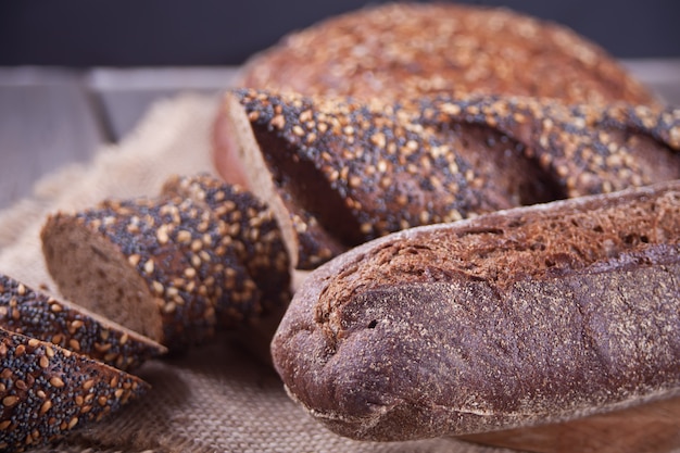 Freshly baked rye bread with cereal and seeds on wooden kitchen table