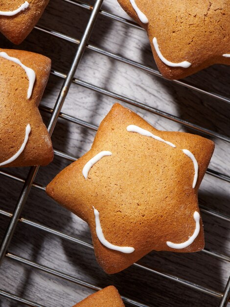 Freshly baked star shaped ginder cookies on cooling rack. Closeup, top view.