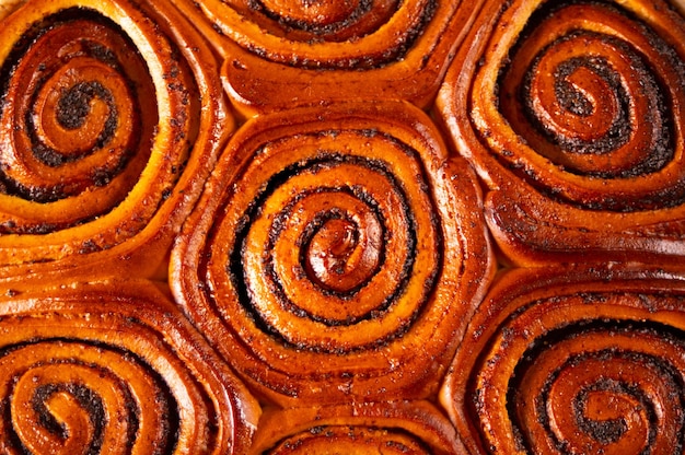 Freshly baked sweet cinnamon bun roll swirl pattern background.