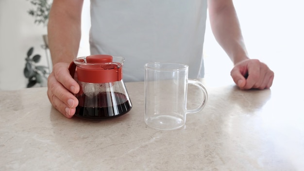 Photo freshly brewed coffee in glass server and glass cup on table. pourover, v60.