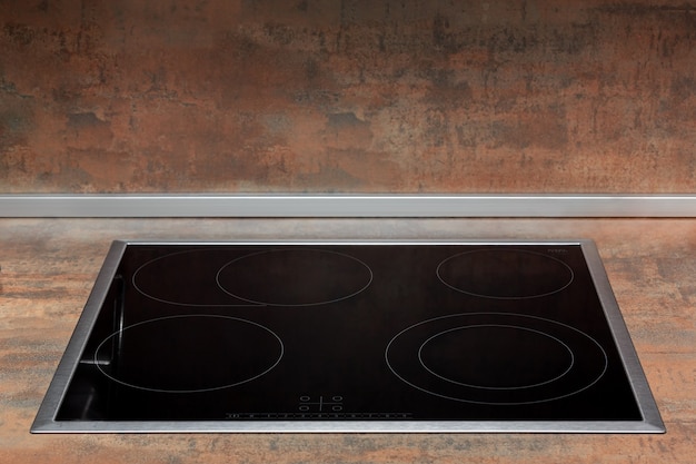 Freshly cleaned glass surface of an electric cooker built into the kitchen worktop